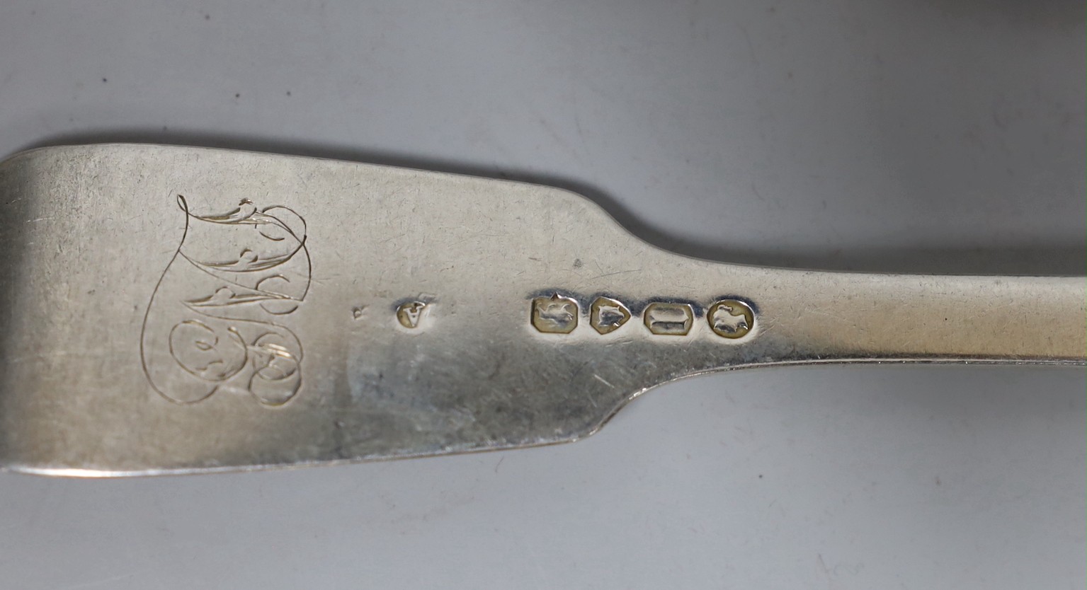 Four assorted items of silver flatware, a sterling serving spoon and a George V silver shoe horn (lacking ring), 10.6oz.